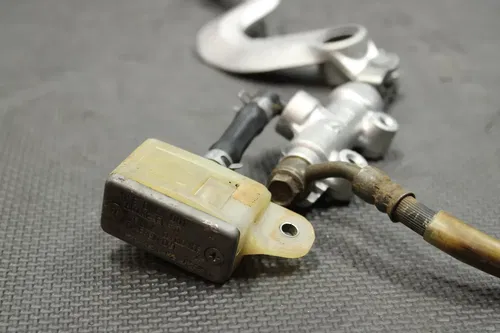 1999 SUZUKI RM250 OEM REAR BACK BRAKE CALIPER MASTER CYLINDER LEVER NEEDS WORK!
