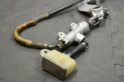 1999 SUZUKI RM250 OEM REAR BACK BRAKE CALIPER MASTER CYLINDER LEVER NEEDS WORK!